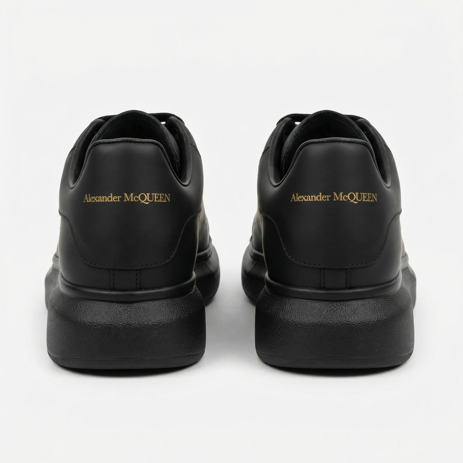 Alexander McQueen Oversized Black Sneakers Back View Pair Gold Logo - SHUZAR Egypt