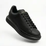 Alexander McQueen Oversized Black Sneakers Front Angle Gold Logo - SHUZAR Egypt