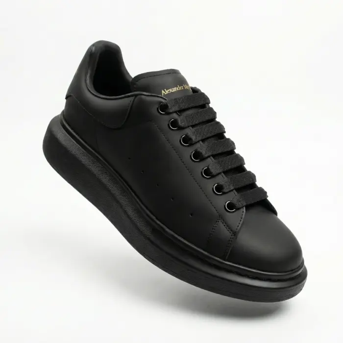 Alexander McQueen Oversized Black Sneakers Front Angle Gold Logo - SHUZAR Egypt